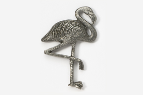 A silver flamingo is standing on one leg.