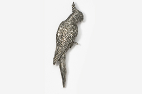 A silver bird sitting on top of a white wall.