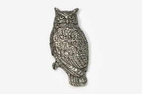 A silver owl sitting on top of a tree.