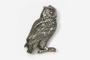 A silver owl sitting on the ground.