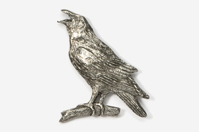 A silver bird sitting on top of a tree branch.