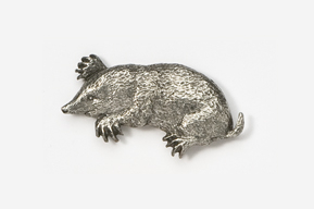 A silver animal is laying down on the ground.