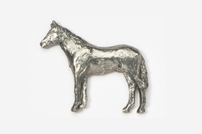 A silver horse is standing in the middle of a field.