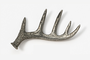 A metal deer antler on top of a white wall.