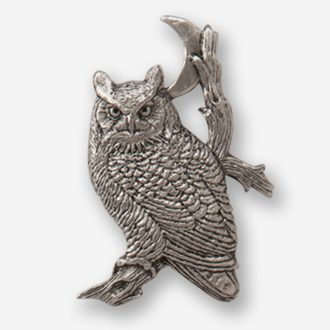 A silver owl sitting on top of a tree branch.