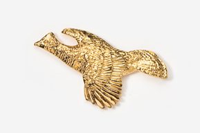 A gold bird is flying in the air.