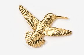 A gold hummingbird brooch is shown on a white background.