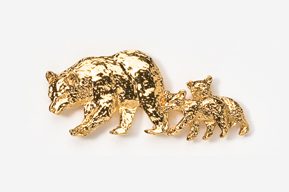 A gold bear and cub pin on a white surface.