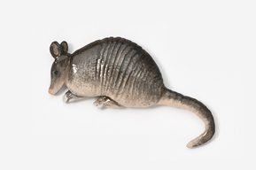 A stuffed animal armadillo is laying down.