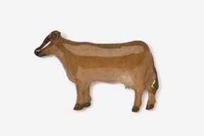 A brown cow standing on top of a white surface.