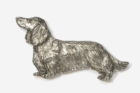 A silver dog is standing up against the wall.