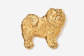 A gold dog shaped cookie is sitting on top of a white surface.