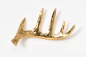 A gold antler brooch is shown on a white background.