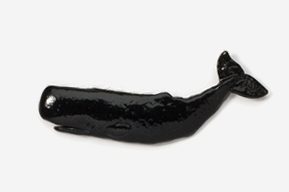 A black plastic whale is laying on the ground.