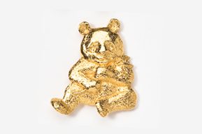 A gold bear is sitting on the ground.