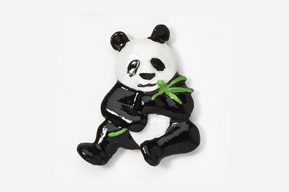 A panda bear holding a bamboo leaf in its paws.