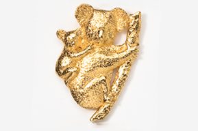 A gold koala bear is hanging on the side of a tree.