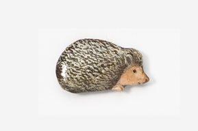 A stuffed animal hedgehog is laying down.