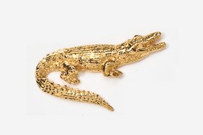 A gold alligator is sitting on top of the floor.