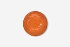 A orange plate sitting on top of a white table.