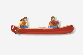 A couple of people are sitting on a canoe