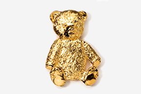 A gold teddy bear sitting on top of a white table.