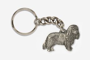 A silver key chain with a dog on it.