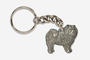 A metal keychain with a dog on it.