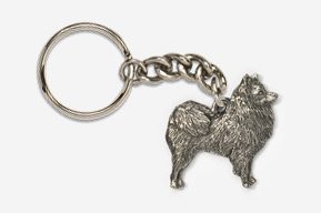 A metal key chain with a dog on it.