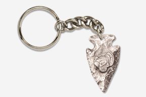 A silver arrowhead keychain with a rose on it.