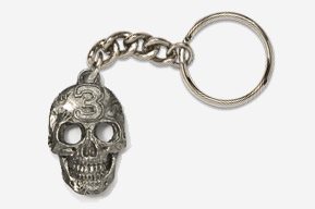 A silver skull keychain with the number 3 on it.