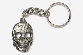 A silver skull keychain with the number seven on it.