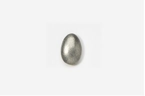 A silver egg sitting on top of a white table.