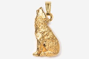 A gold pendant of a wolf sitting on top of the ground.