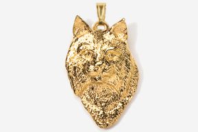 A gold colored pendant with a dog 's head on it.