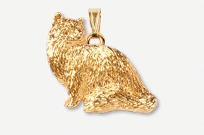 A gold cat pendant sitting on top of a white surface.