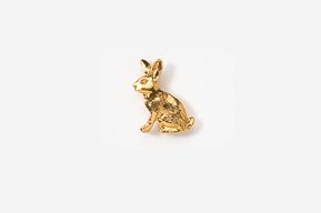 A gold rabbit sitting on top of a white surface.