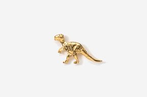 A gold plated dinosaur pin on a white background